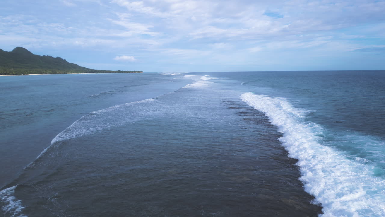 Towering waves crash and roll whitewash over fringing reef of Rarotonga Cook Islands