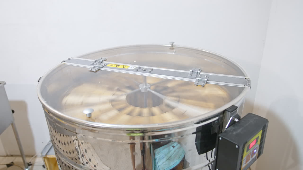 Electric device for extracting honey from frames. Centrifuge with frames rotating inside the metal barrel.