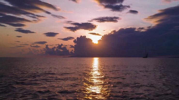 Sunset over the Ocean with Sailboats