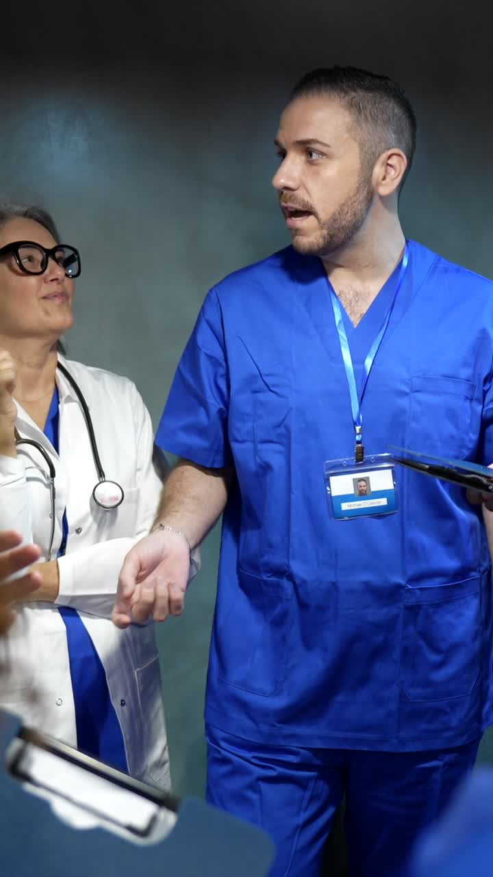Professionisti medici in divisa chirurgica e camice bianco che discutono.