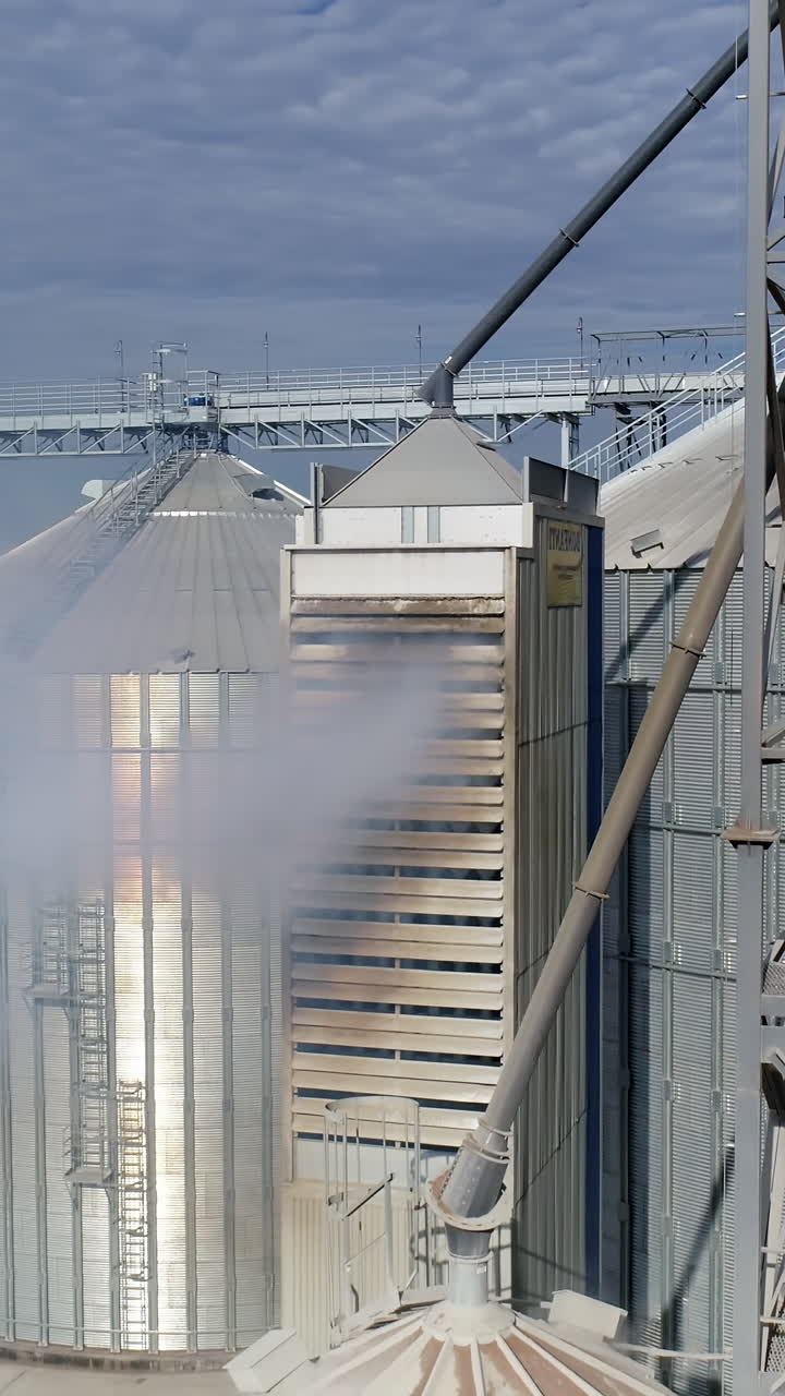 Modern industrial grain elevators. Big elevator metal construction. Aerial view. Vertical video