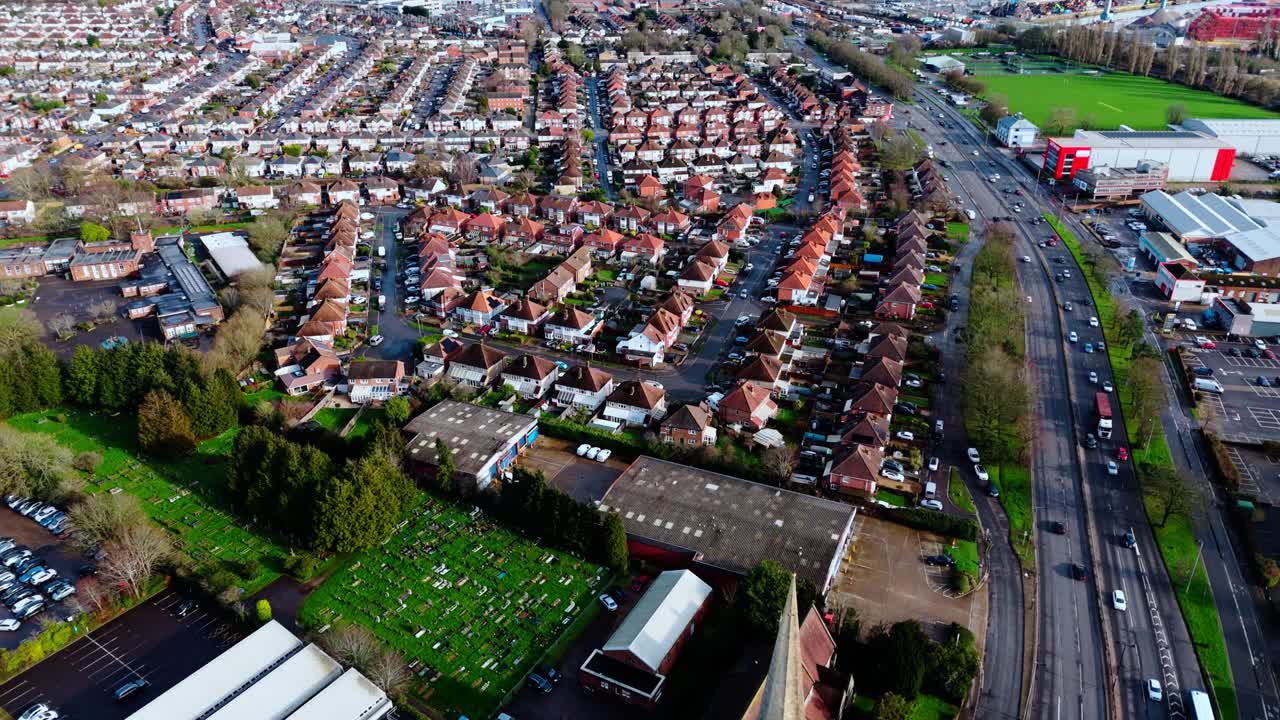 Luftaufnahme einer Drohne aus großer Höhe über dem Vorstadtwohngebiet Millbrook in Southampton bei Sonnenuntergang mit Bäumen, Häusern und umgebender Natur. Aufgenommen im Winter mit Verkehr und Autos auf den Straßen.