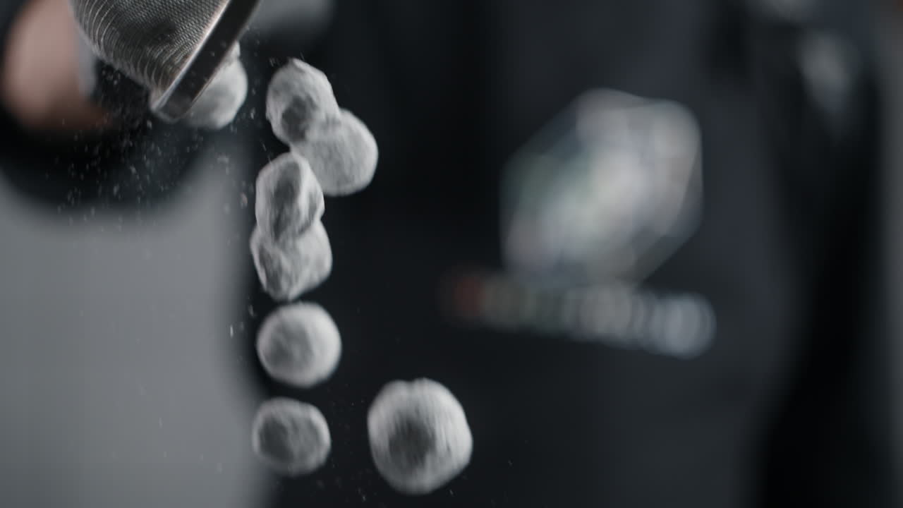 Chef Sifting Powdered Sugar Over Small Balls