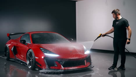 man washing a red sports car