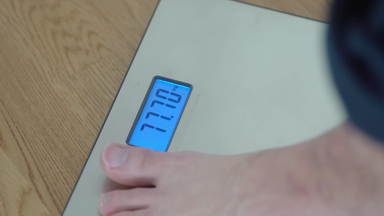 Closeup shot of man stepping on a weight scale