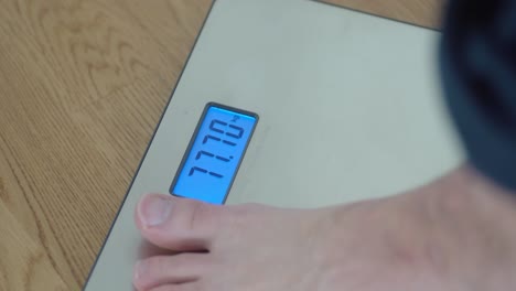 closeup shot of man stepping on a weight scale