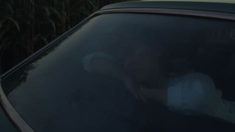 woman in a vintage car at sunset