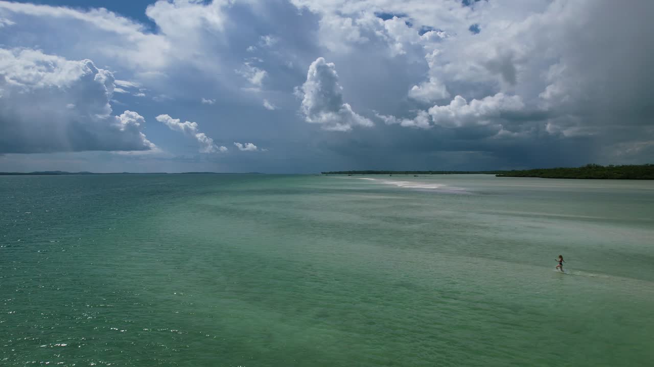맑고 투명한 열대에서 달리는 어린 행복한 소녀