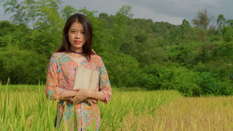 joven ingeniera mujer agricultora de pie en el campo de arroz con una tableta portátil moderna comprobando la eficiencia de la producción en la agricultura de precisión