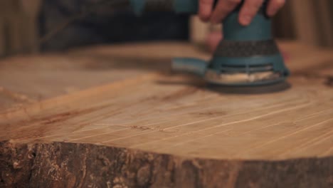 Extremely-close-shooting-of-manual-grinding-process-in-carpenter's-hand.-Wood-dust