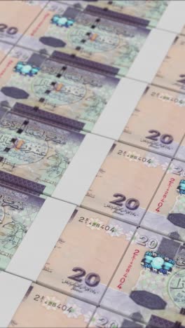 vertical video of 20 libyan dinar banknotes printed by a money press