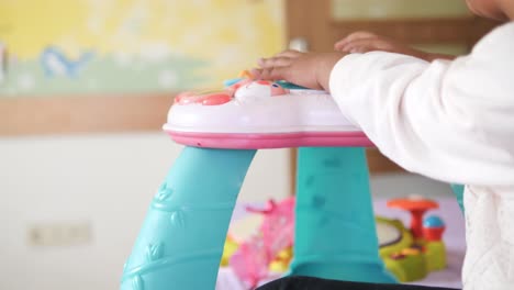 baby playing with toys in an activity center