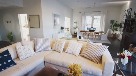 a comfortable family living room with white walls and dark wood floorboards, handheld