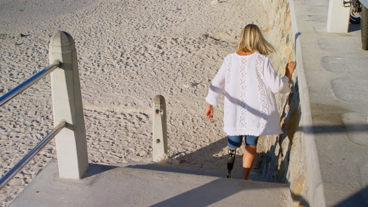 Donna disabile che scende le scale in spiaggia 4k