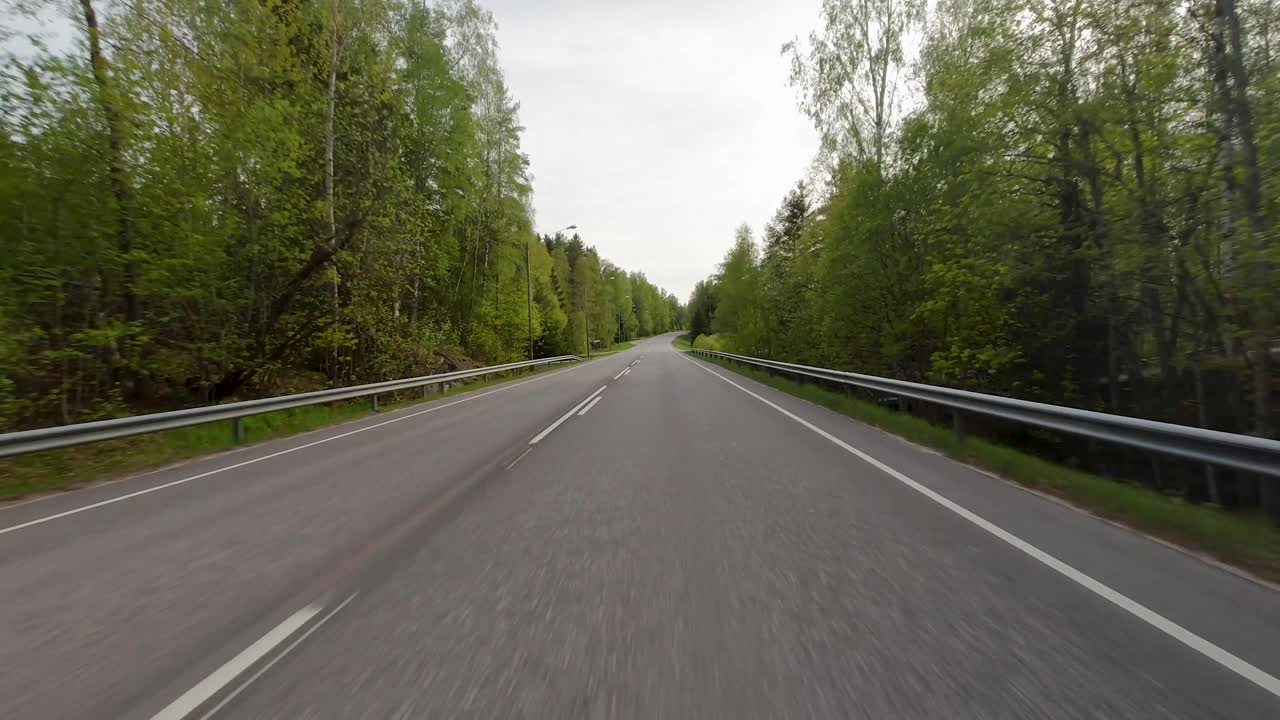 길 은 광활 한 초록색 들 을 가로질러  ⁇ 고 있으며, 웅장 한 나무 들 이 풍경 에 산재 해 있다