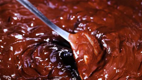 spoon stirring thick, glossy chocolate batter