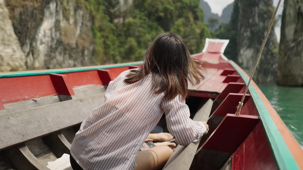 Woman enjoys a scenic longtail boat trip through stunning limestone cliffs and tropical waters