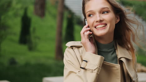 estudiante caucásica hablando por teléfono al aire libre.
