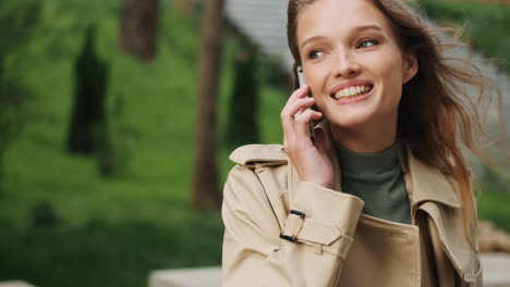 caucasian female student talking on the phone outdoors.