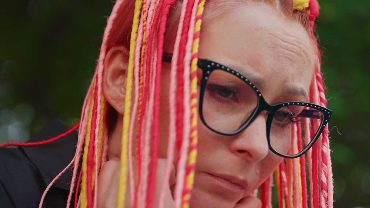 dama poética y tranquila, mujer reflexiva con trenzas brillantes, dama apacible absorta en profundos pensamientos con cabello colorido, figura femenina serena dedicada a una meditación intensa con cabello llamativo