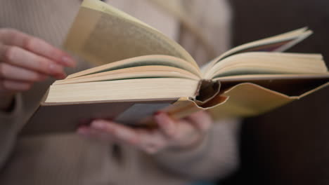 close-up of a hand gently flipping a book page, showcasing the page-turning process, with the book open pages and finger motion captured against a soft background