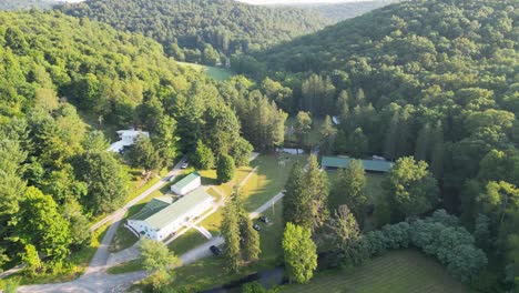 a serene aerial shot of countryside homes nestled between lush green hills