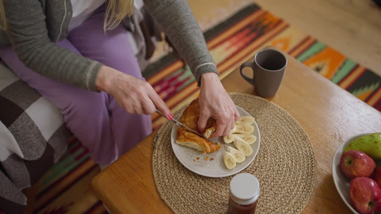 Preparing a breakfast of croissants, bananas, and fruit