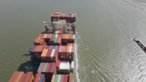 aerial pan left over container ship loaded sailing on sunny day