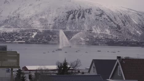 Wide-shot-of-Traditional-Boat-Parade-During-Norwegian-Constitution-Day-In-Tromso-with-gigantic-snowy-mountains-in-background