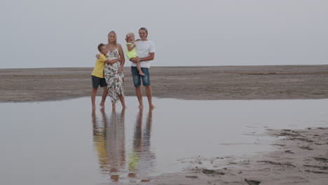 Retrato-Familiar-En-La-Playa,-Padres-Con-Dos-Niños-Encantadores