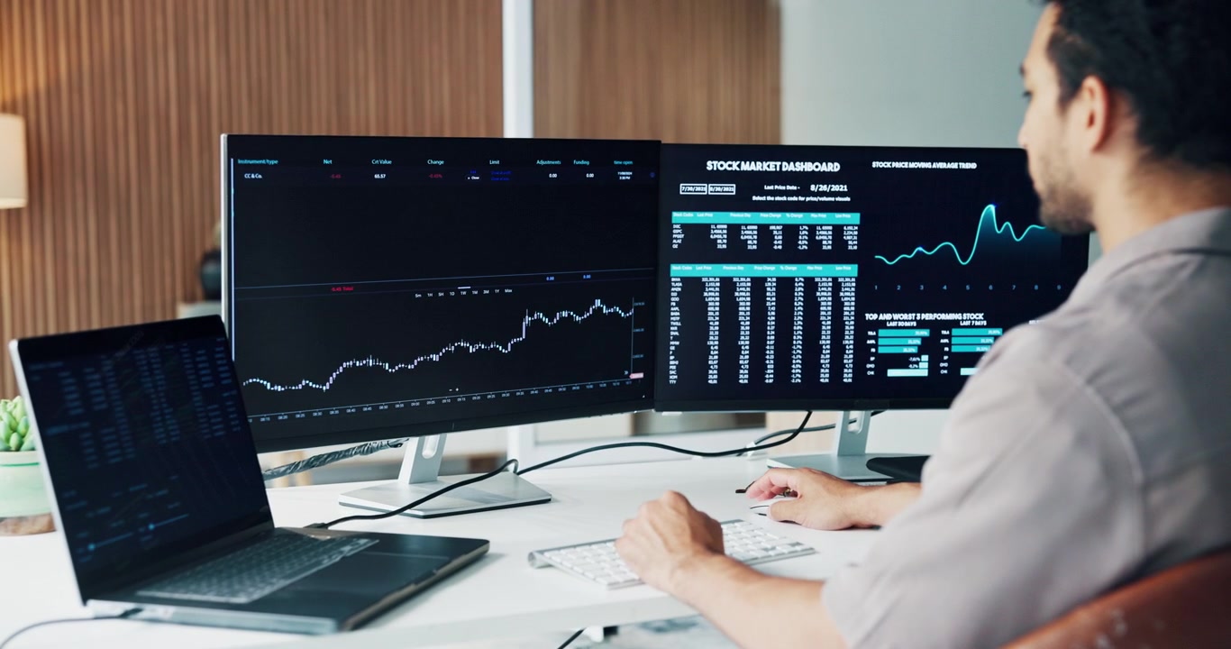 Financial Analyst Monitoring Stock Market Trends on Multiple Computer Screens