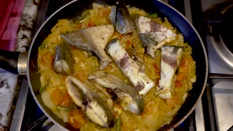 overhead view of fish curry being fried in