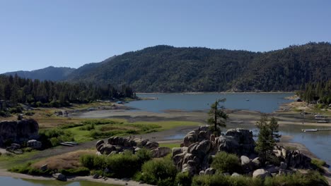 A-stunning-drone-shot-flying-over-a-rock-formation-towards-a-forest-area-at-Big-Bear-Lake-in-San-Bernardino-County,-California