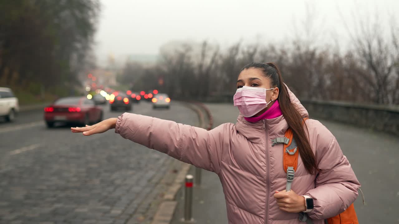 도시에서 승용차를 기다리는 여자