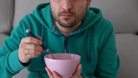 man trying to eat soup after dentist appointment, can't open mouth because of toothache