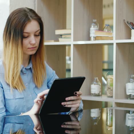 a young caucasian woman rests in a cafe uses a tablet 1