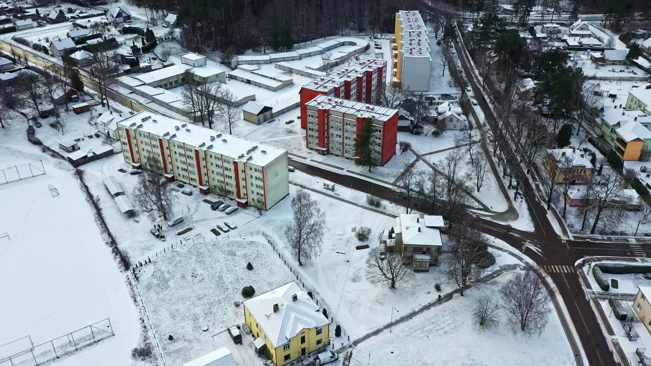 Vinterligt boligområde med boligbygninger, veje og self storage garager i luftperspektiv