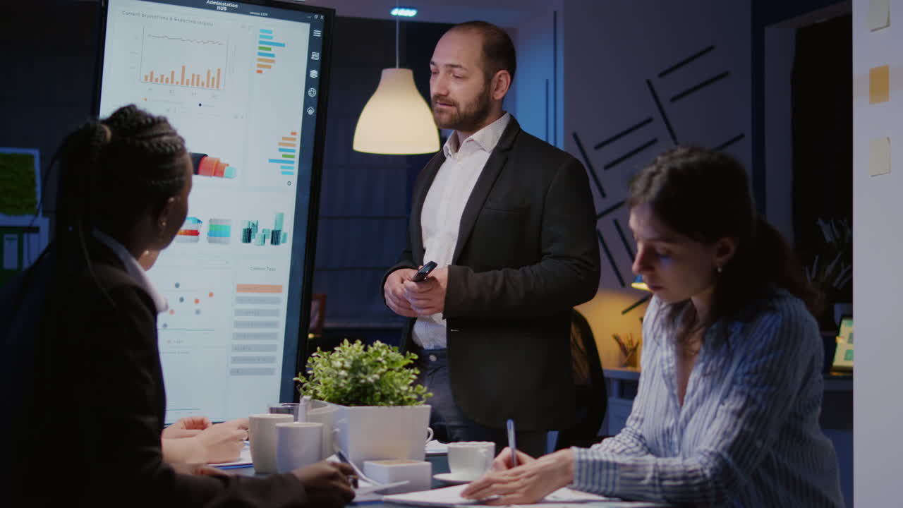 Focused man leader explaining management project using monitor working in company meeting office room