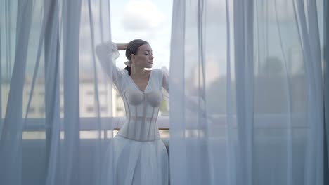 woman in white corset dress on balcony