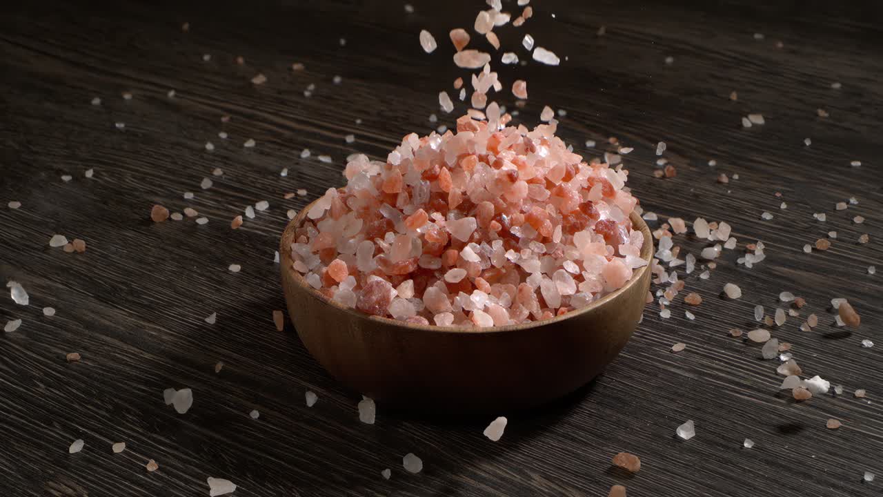 Sale rosa dell'Himalaya al rallentatore, condimento minerale naturale per cucina salutare e idee spa. Super slow motion 1500 fps