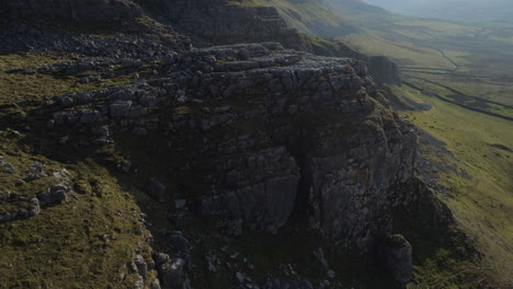 lenta toma aérea de drones volando sobre warrendale nudos yorkshire dales campo hierba y colinas rocosas con paredes de piedra seca y cría de ovejas en el soleado día de verano reino unido