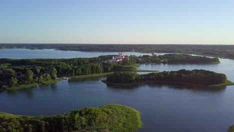 aerial shot over many small lakes and closing in to a church in the distance