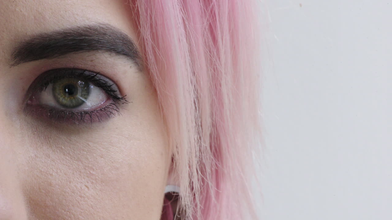 close up woman eye open looking at camera punk female pink hair on white background