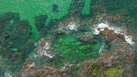 ocean waves crash over a cornish coastal rock pool at constantine bay in cornwall, uk