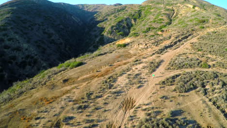 Toma-Aérea-Sobre-Las-Laderas-Del-Sur-De-California-Con-Un-Excursionista-Debajo