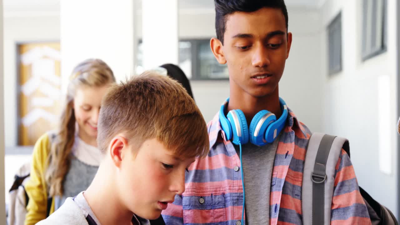 노트북 과 디지털 태블릿 을 가지고 복도 에 서 있는 학생 들