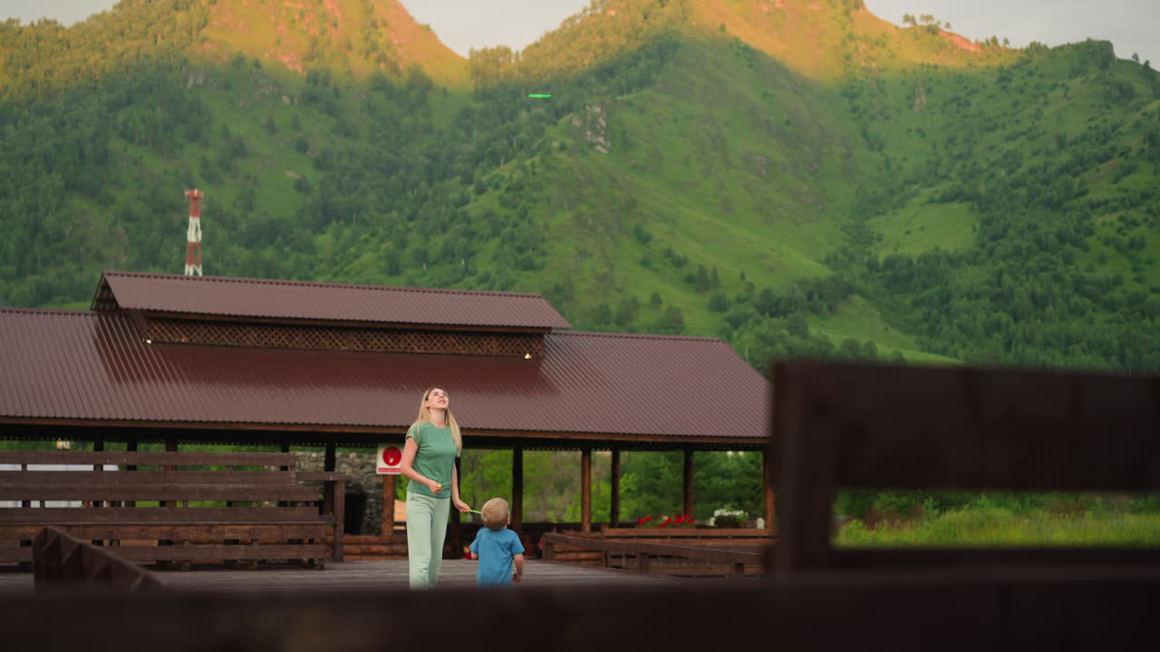 어머니는 하이랜드 리조트에서 아이들과 함께 날아다니는 장난감을 발사합니다.