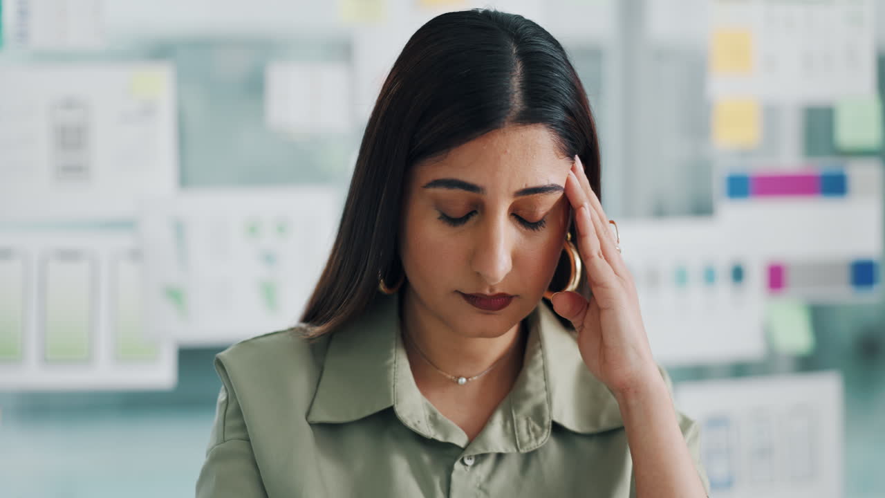 Stressed businesswoman with headache in office