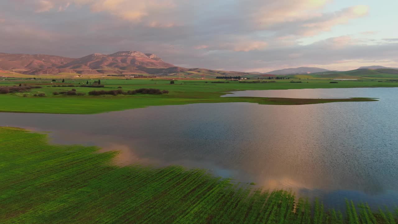 반사와 석양 그리스의 녹색 필드로 둘러싸인 호수