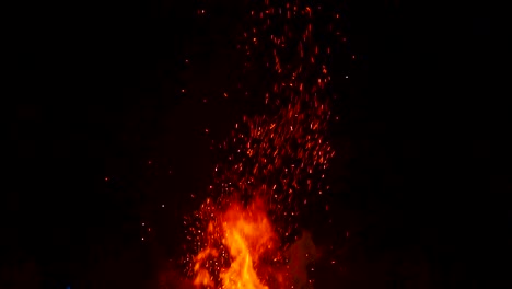 Zeitlupe,-Die-Von-Einem-Lagerfeuer-Zum-Dunklen-Himmel-Schwenkt,-Wobei-Funken-Vom-Feuer-Auffliegen